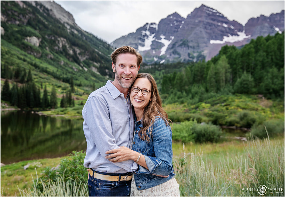 Happy couple pose for a professional portrait with Maroon Bells in the Backdrop in Aspen Colorado