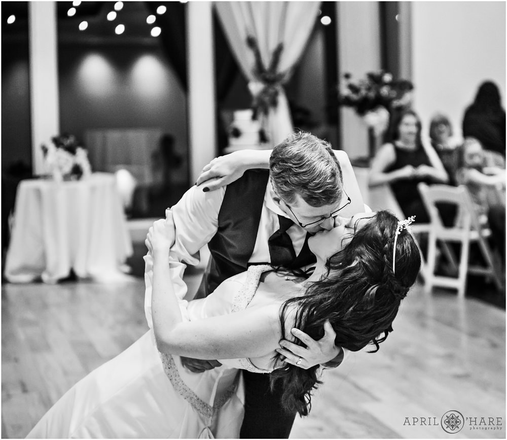 Groom dips his bride and kisses her after first dance at their Ashley Ridge Wedding Reception in Littleton