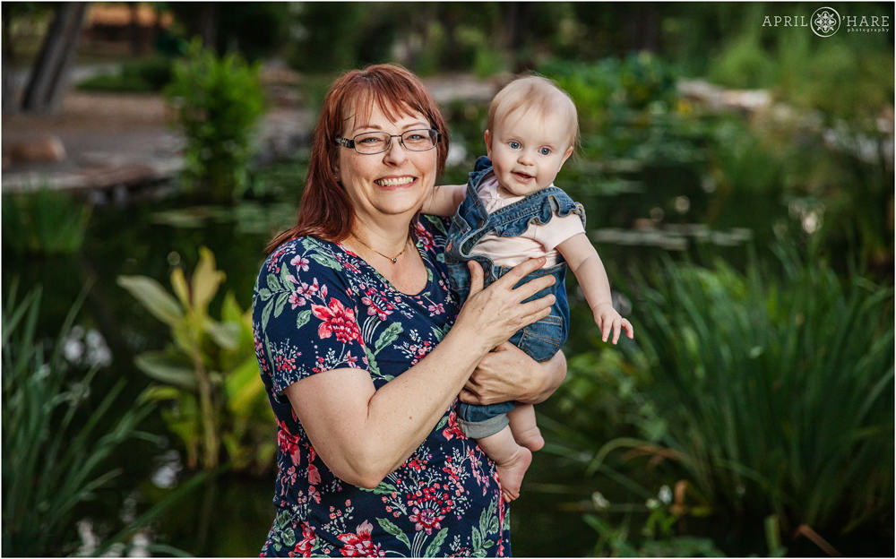 Grandmother with her granddaughter during family photos with pretty water garden backdrop in Littleton