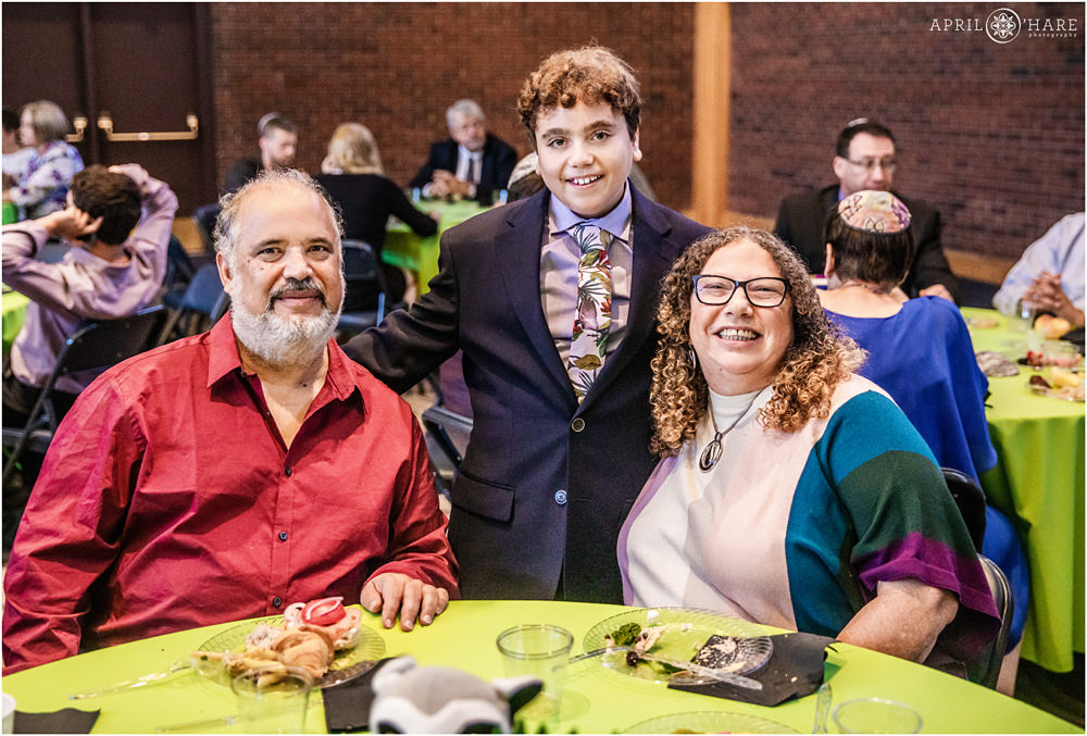 Bar mitzvah boy poses for a candid photo with his guests at kiddush at Temple Emanuel