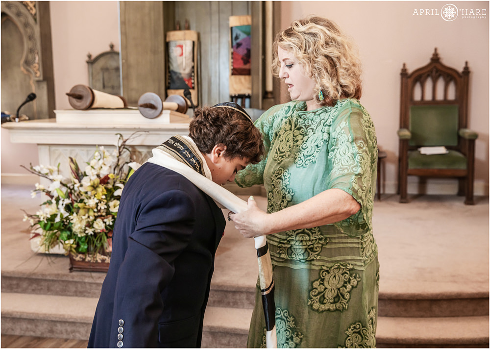 Mom helps her son with his tallit at his bar mitzvah service at Temple Emanuel in Denver Colorado