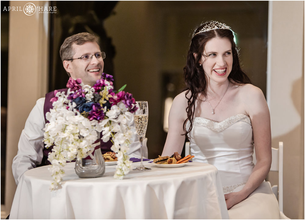 Bride wearing tiara sits with groom at Sweetheart Table at Ashley Ridge Wedding Reception