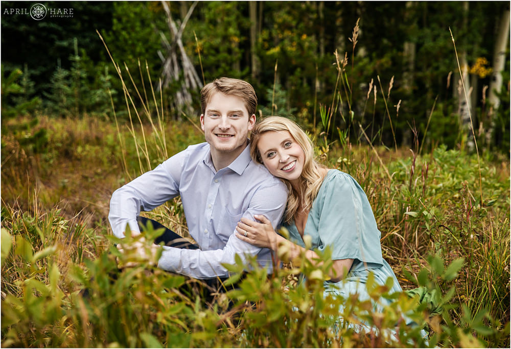 Young couple sitting in a Colorado mountain forest in Evergreen Colorado