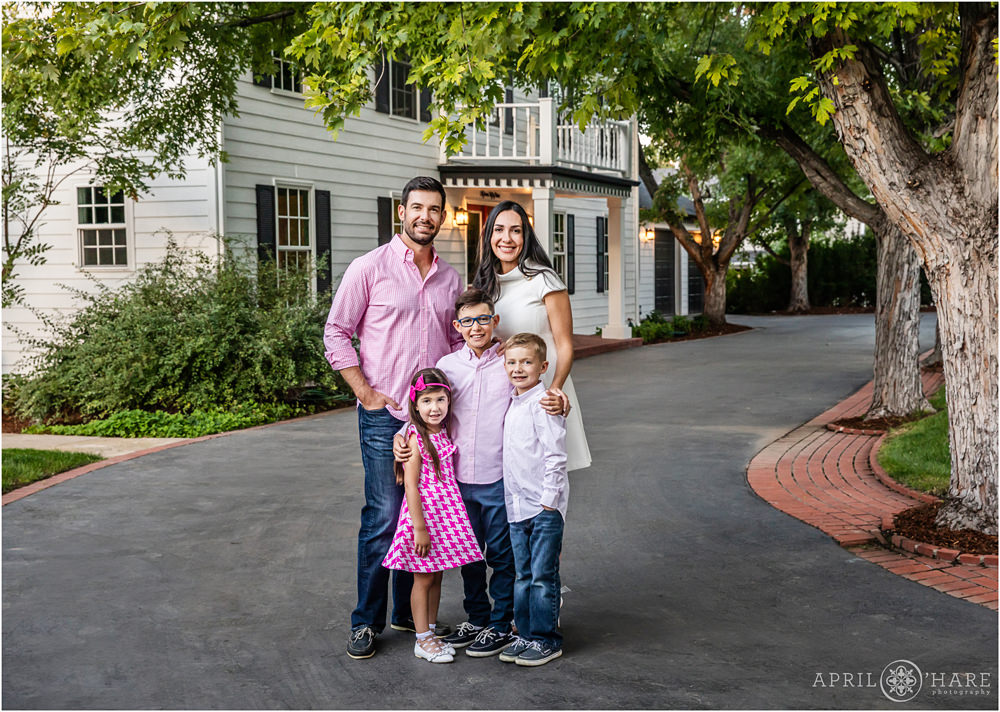 Family with young kids wearing pink pose for portrait in front of their home in Denver