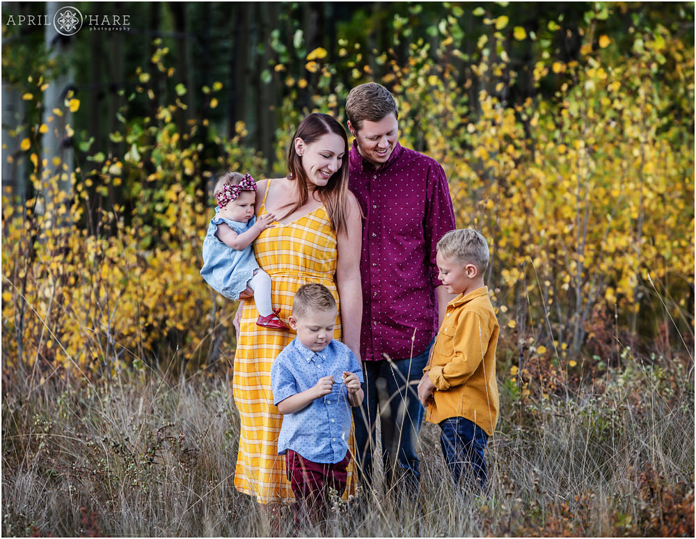 Candid family portrait in the yellow aspen tree fall foliage in Evergreen Colorado