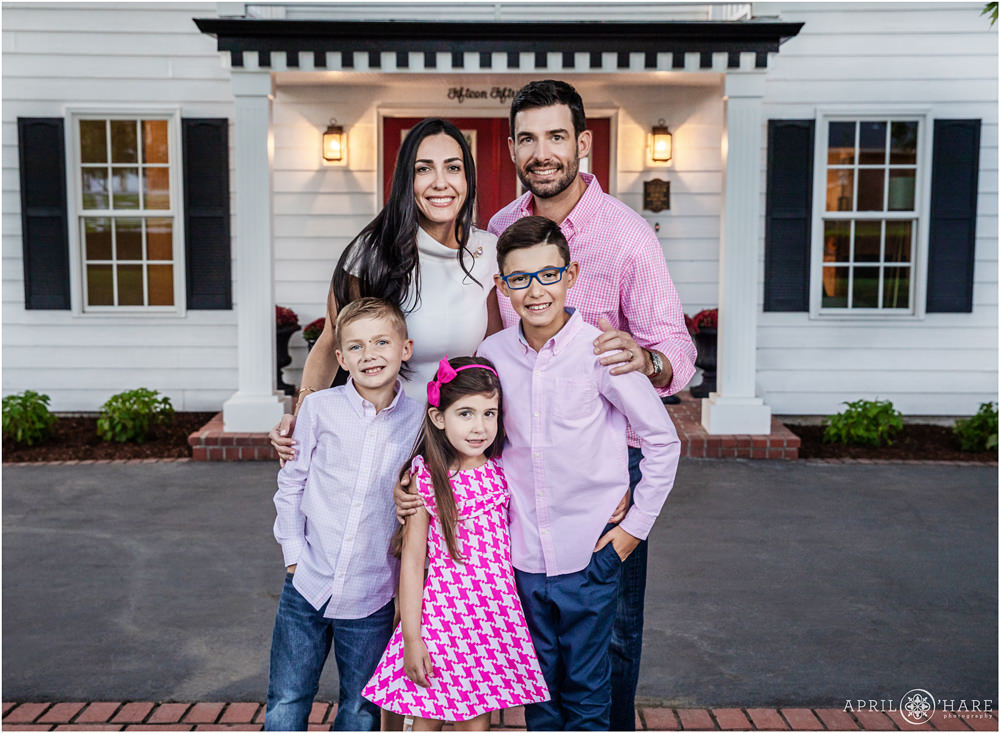 Family wearing pink pose for a portrait in front of their home in Denver Colorado