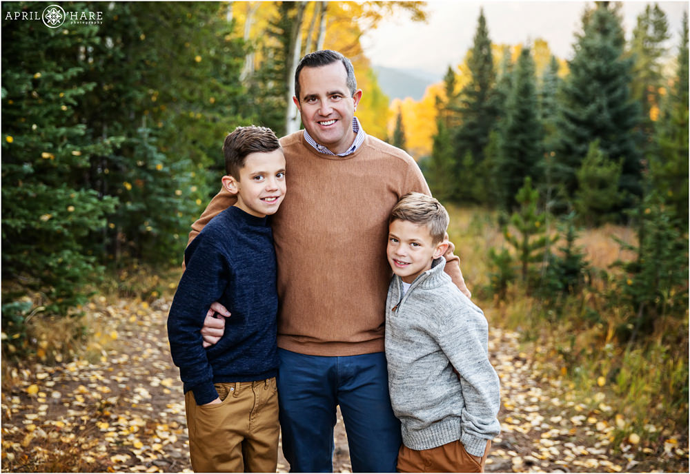 Beautiful fall color portrait of a dad with his two sons on a hiking trail in Evergreen Colorado