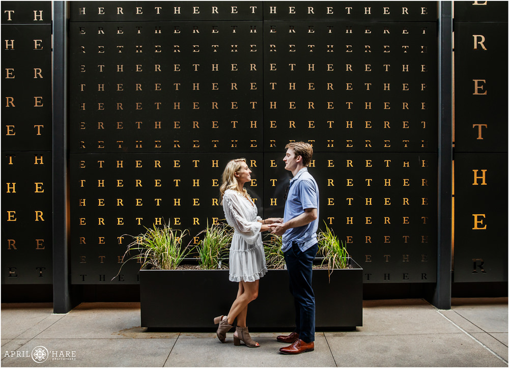 Cute couple in front of there wall at Hotel Born Denver Engagement Photography