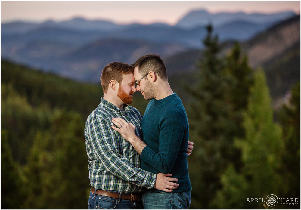 Sweet romantic Colorado engagement photo with two men in front of a pretty mountain backdrop