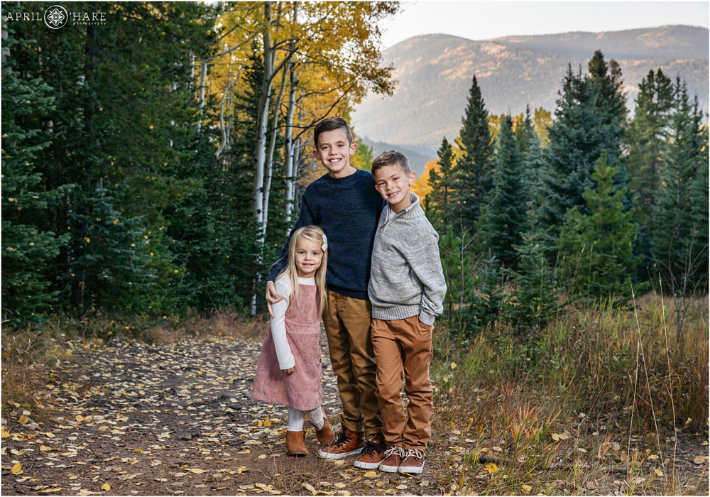 Sibling portrait during autumn with mountain backdrop on Squaw Pass Road in Colorado
