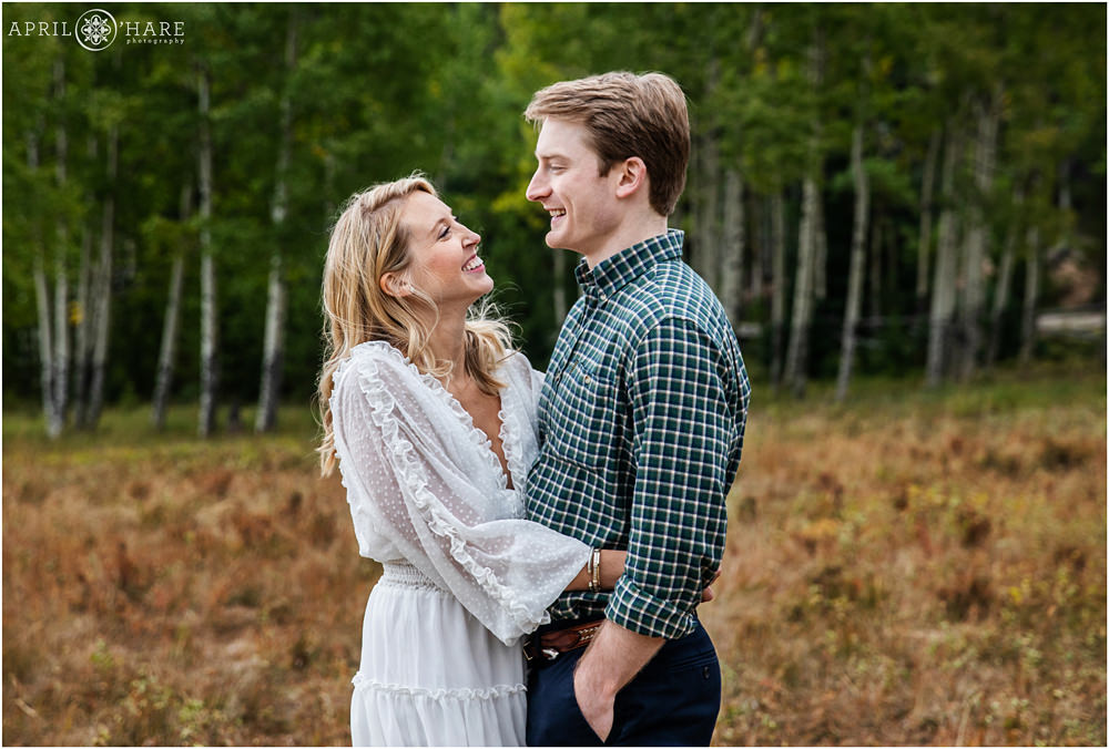 Smiling happy couple at their fall color engagement photography session in Evergreen Colorado