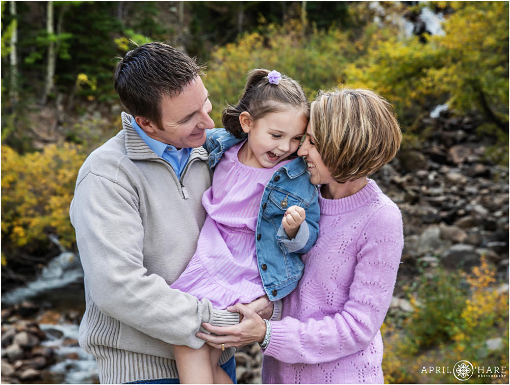 Family wearing shades of lilac snuggles during their fall color family photography session on Guanella Pass in Colorado