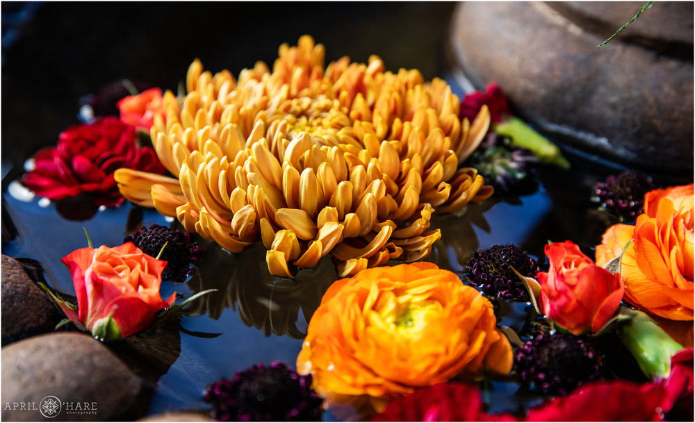 Orange florals floating in a fountain wedding decor at Villa Parker during Autumn in Colorado