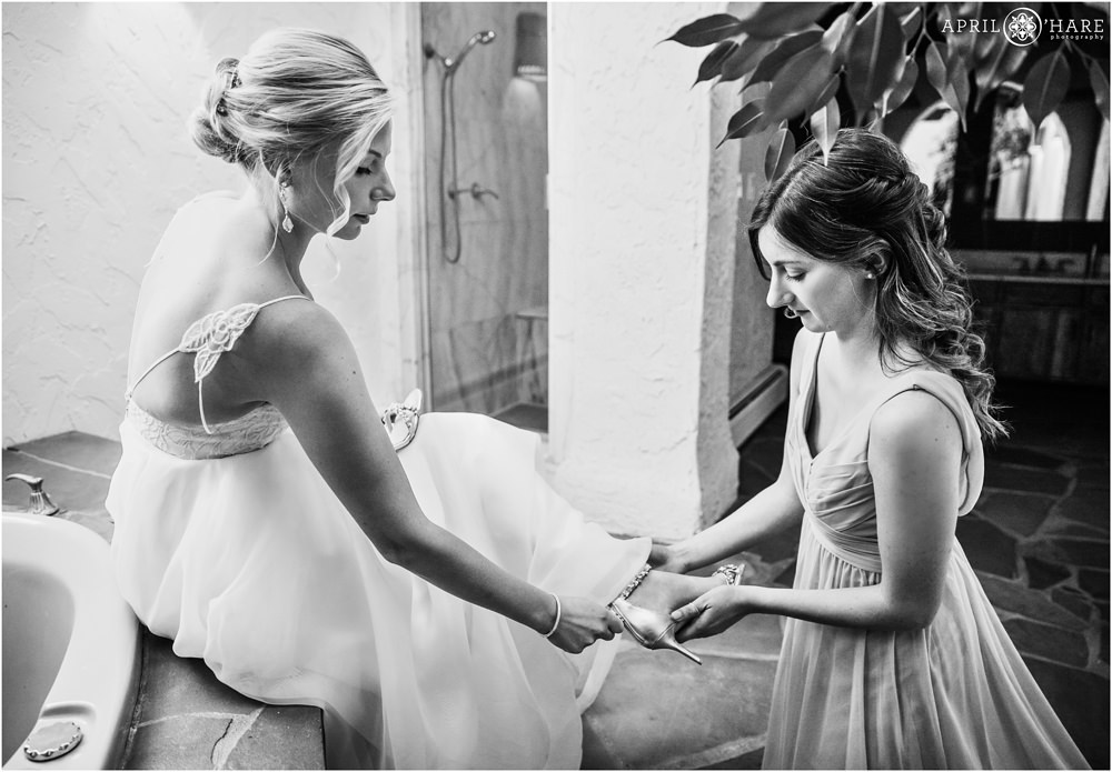 Maid of honor helps the bride with her high heels at Villa Parker in Colorado