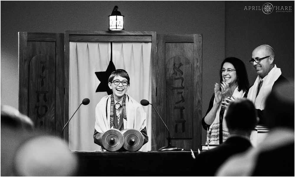 Bar mitzvah boy smiles big as he finishes his torah reading at his bar mitzvah service in Fort Collins Colorado