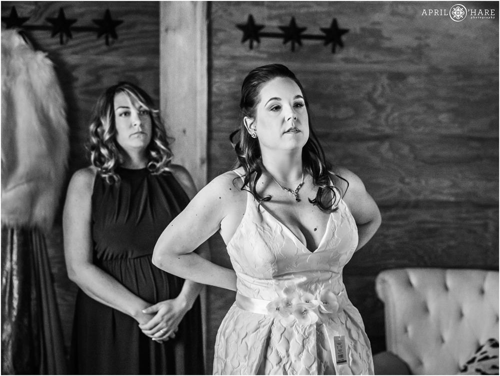 Bride tries on various sashes on her wedding day at the rustic Piney River Ranch in Vail Colorado