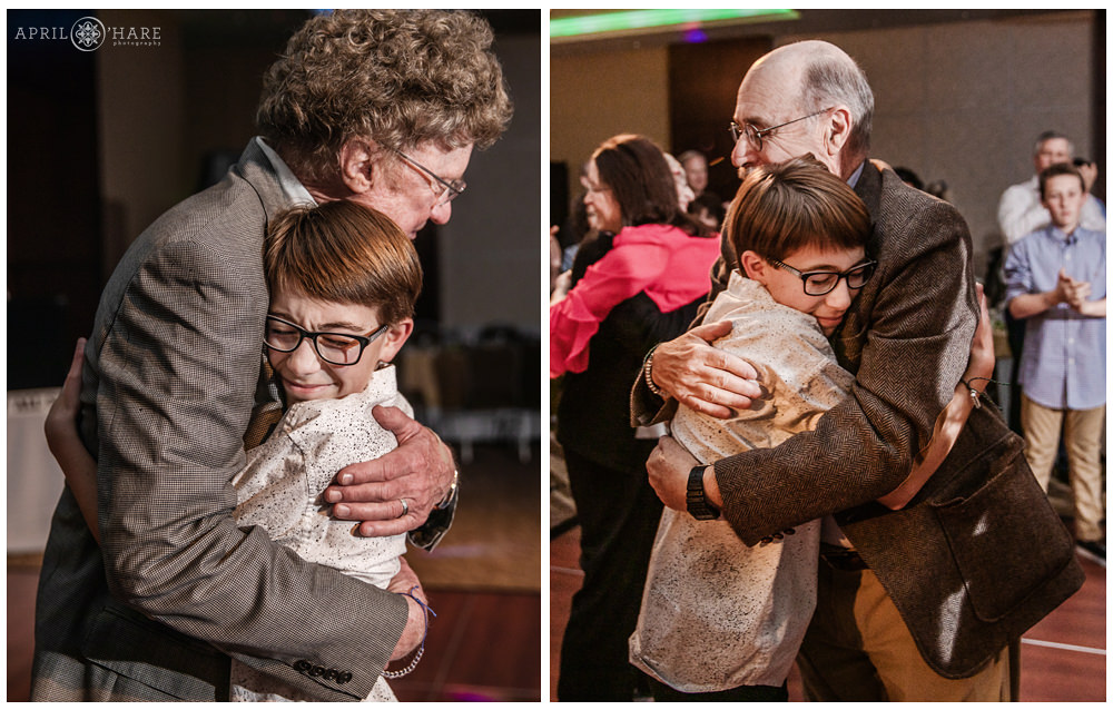 Bar Mitzvah boy hugs both of his grandfathers during his party at the Lincoln Center in Fort Collins