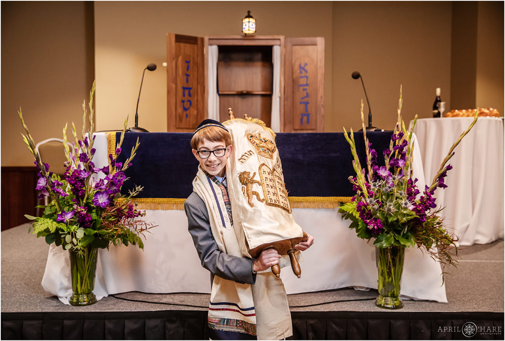 A young man holds the Torah for a portrait at his Bar Mitzvah in Fort Collins Colorado