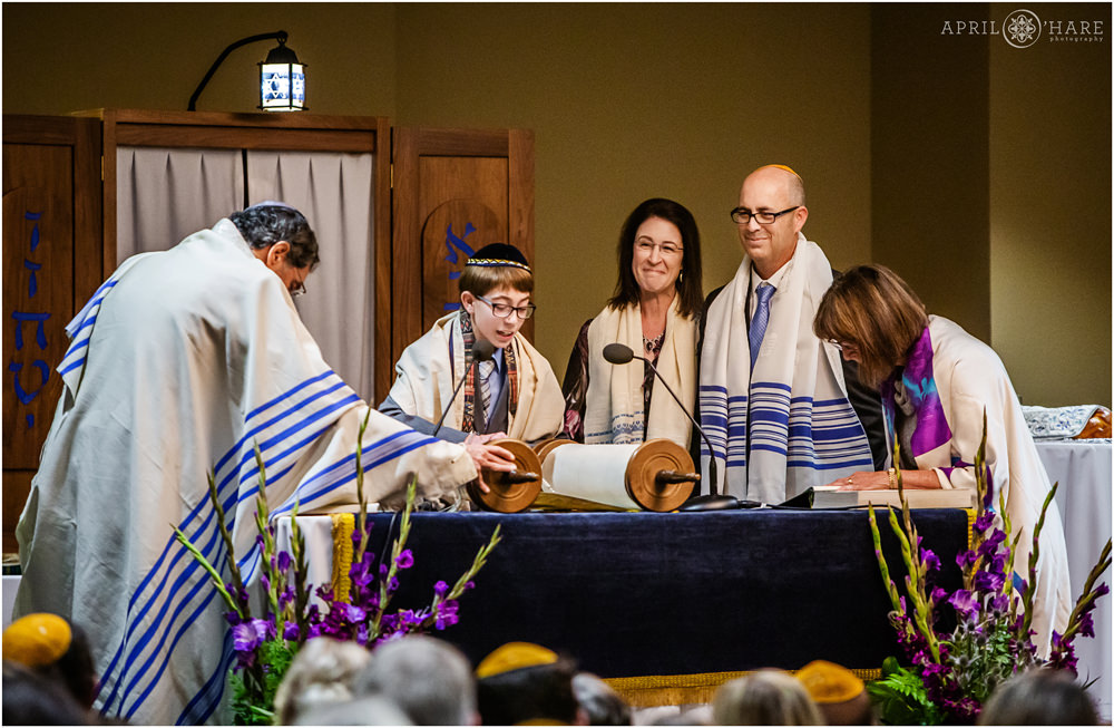 Bar Mitzvah Boy Reads from Torah with his proud parents looking on at Lincoln Center Fort Collins Colorado