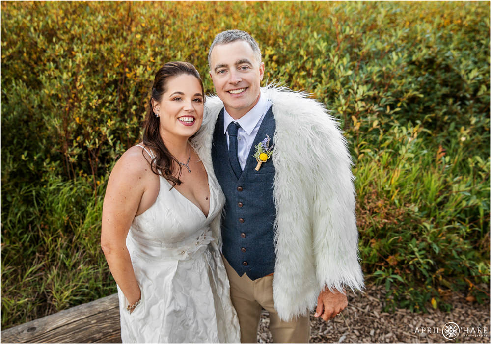 Funny photo of groom wearing his bride's fur jacket at their Autumn wedding in Vail