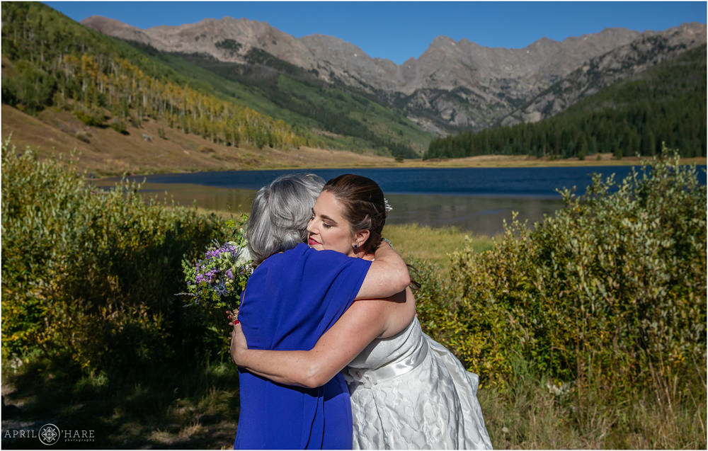 Bride hugs her mom with a nice mountain backdrop behind them in Vail