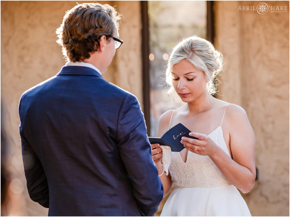 Bride and her vows in the courtyard at Villa Parker during autumn in Colorado