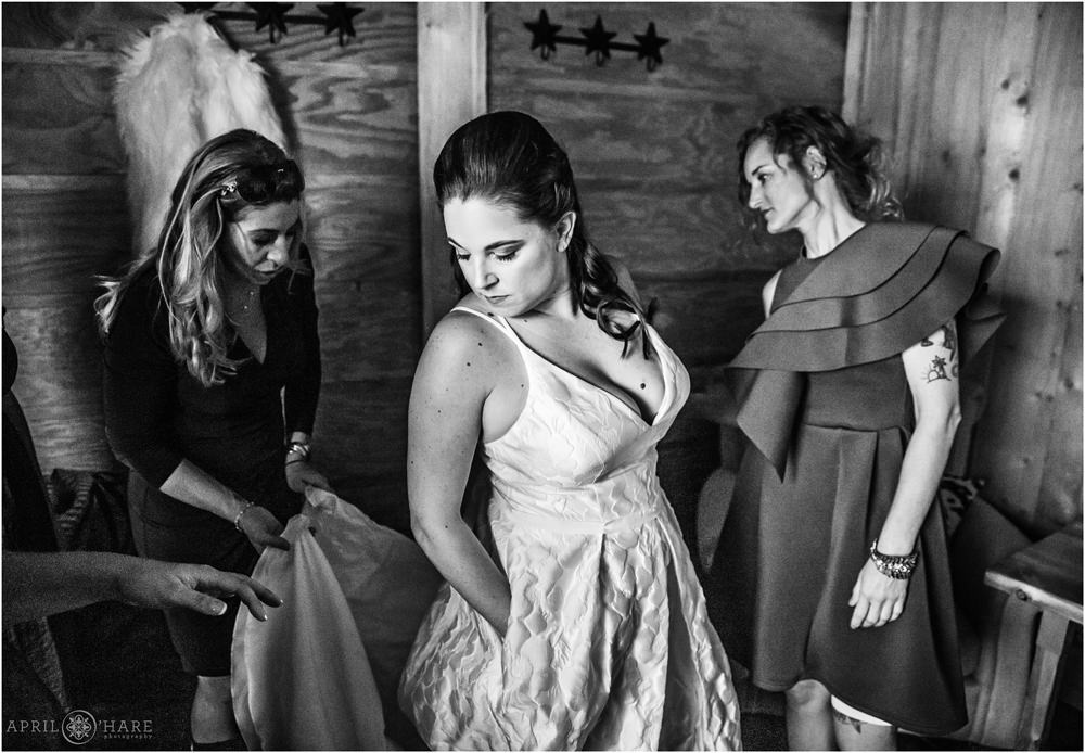 Cute B&W Photo of a bride wearing a dress with pockets as her bridesmaids fuss around her