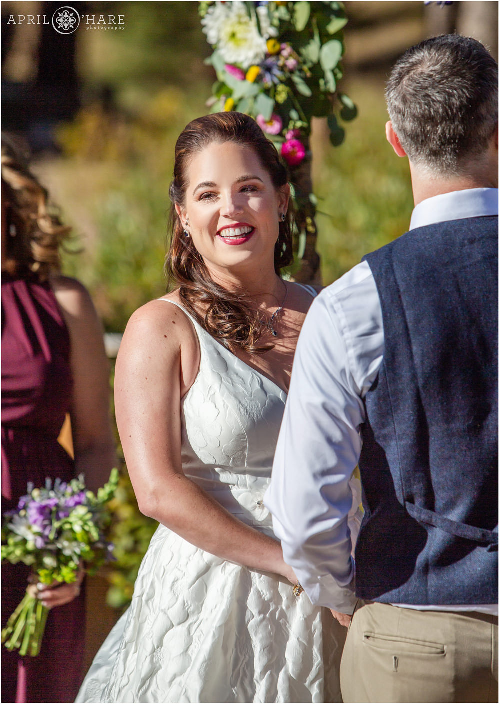 Bride smiles at her outdoor wedding ceremony on a bright sunny day in September