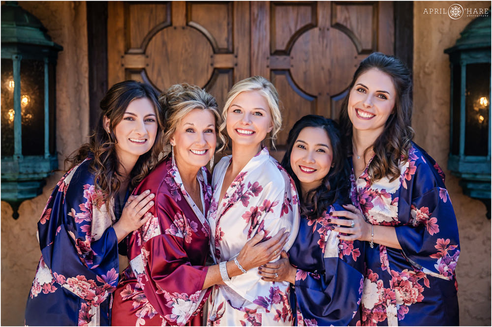 Beautiful photo of a bride with her mom and friends all wearing silk floral robes at Villa Parker in Colorado