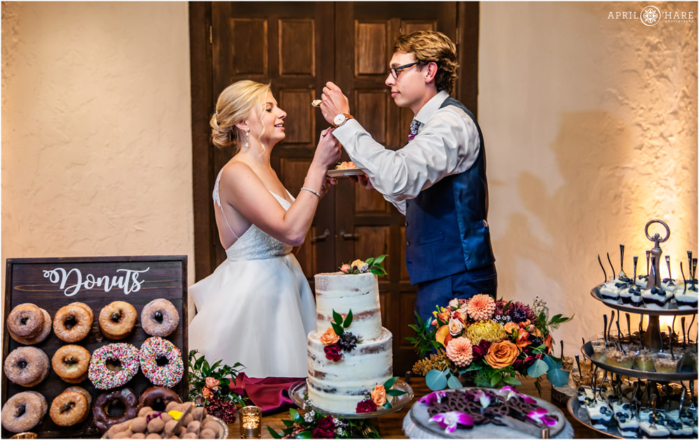 Bride and groom feed each other cake at their Villa Parker wedding reception in Colorado