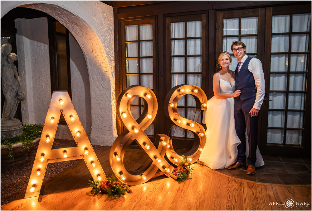 Bride and groom photo with their large industrial lit letter initials decorating their reception dance floor at Villa Parker