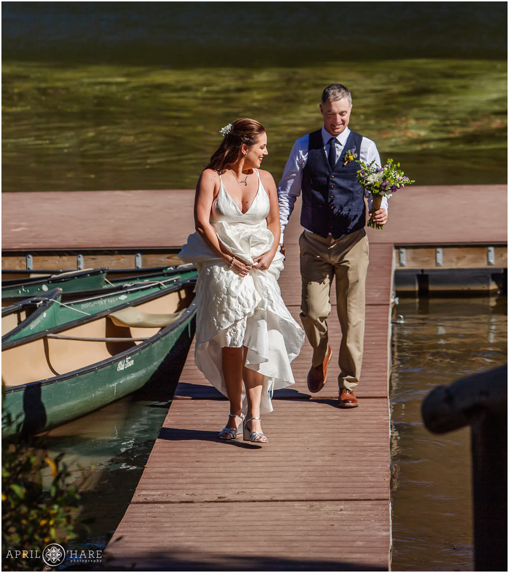 Bride and groom walk along the dock at Piney River Ranch in Vail