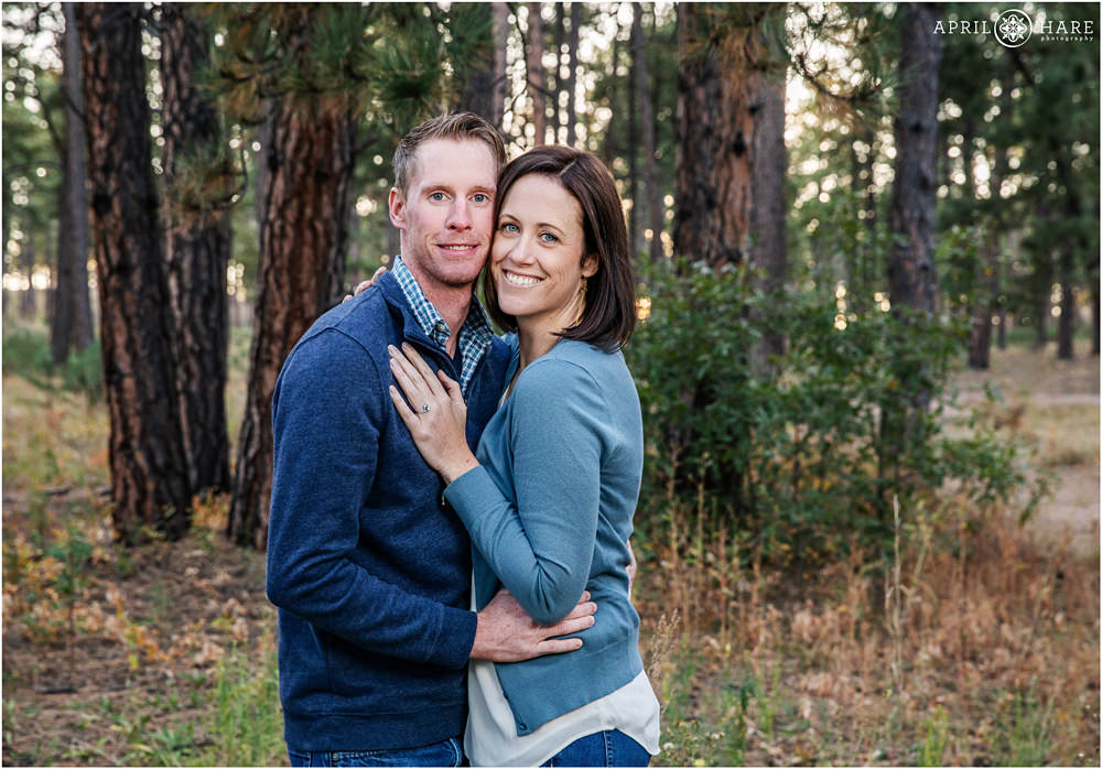Engaged couple embrace in a pretty forest at Fox Run Regional Park in Colorado Springs