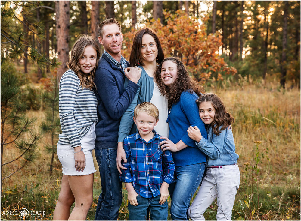 Adorable blended family portrait with fall color backdrop in a pine tree forest at Fox Run Regional Park