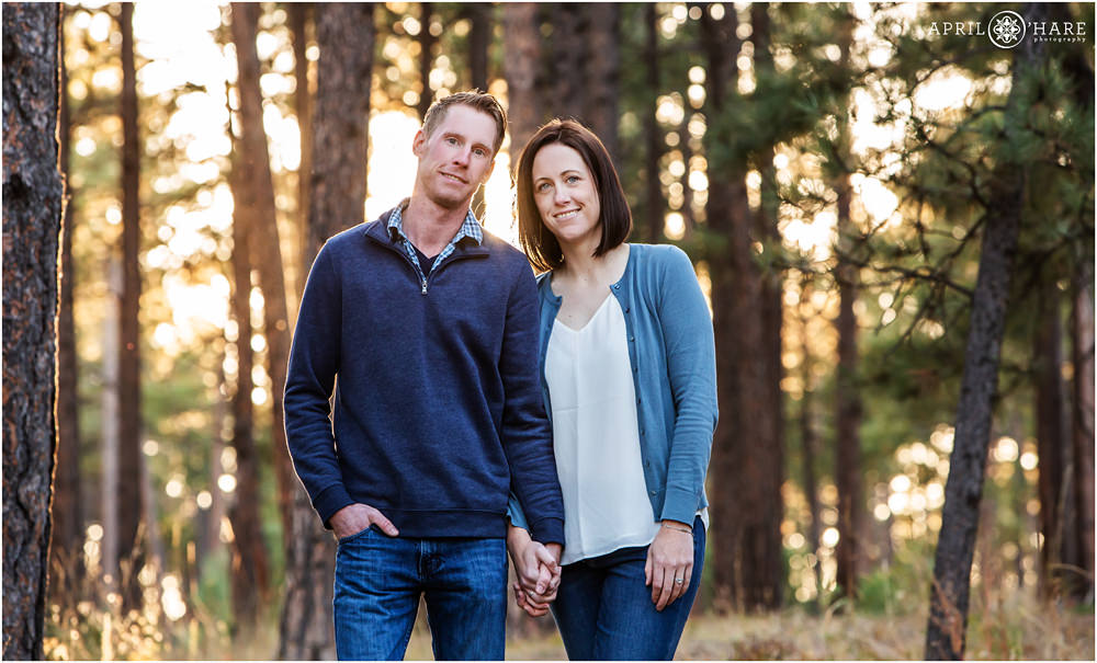 Classic hand holding engagement photo with pretty light in a pine tree forest in Colorado Springs