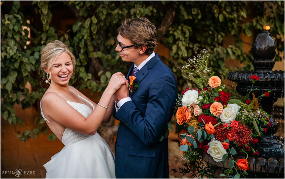 Adorable picture of a bride cracking up during the romantic photo time at their autumn wedding at Villa Parker in Colorado