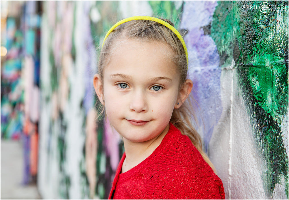 Cute young girl in front of colorful wall mural in Rino area of North Denver Colorado