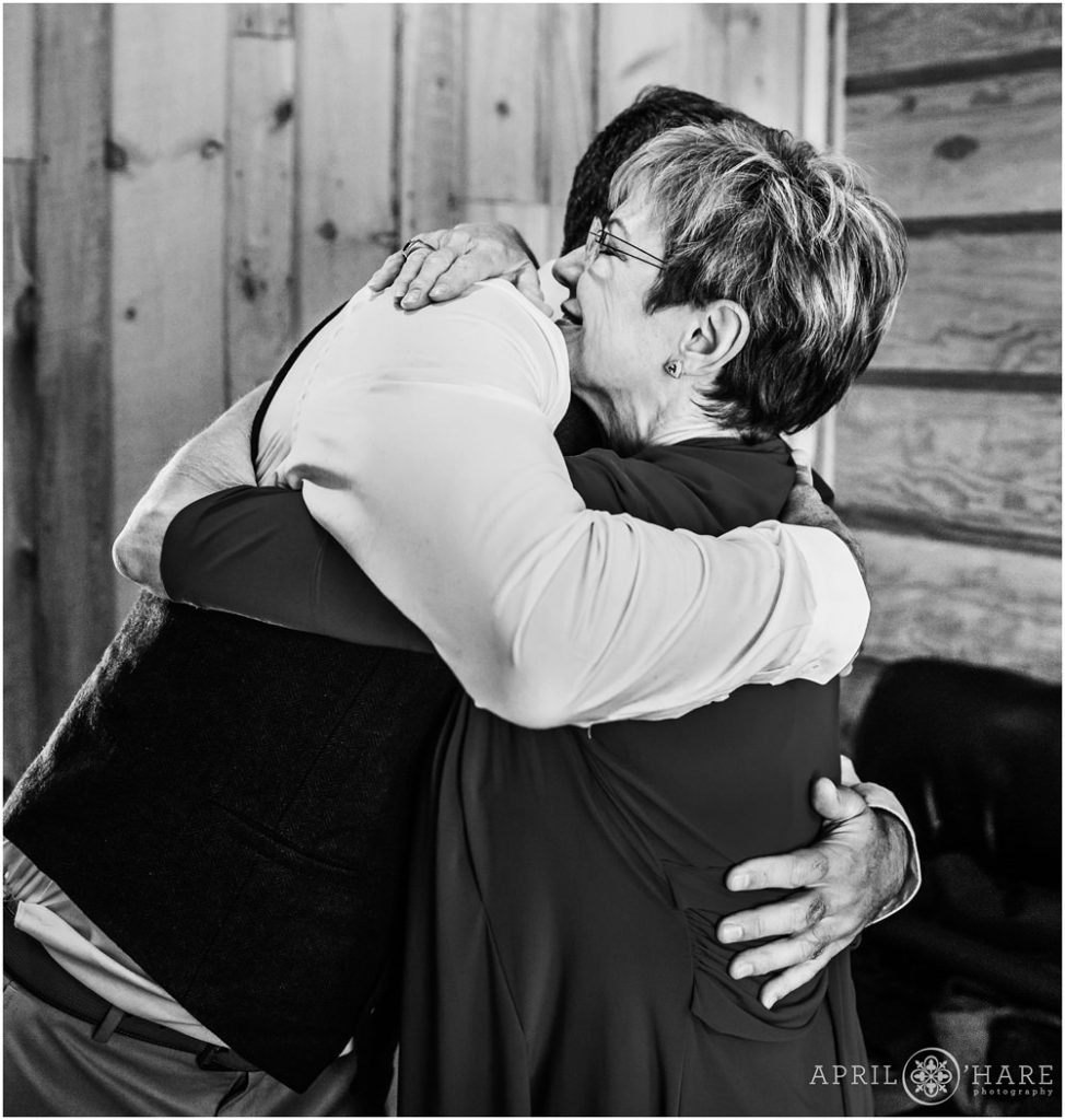 Groom hugs his mom in the dressing room at his rustic Vail mountain wedding in Colorado