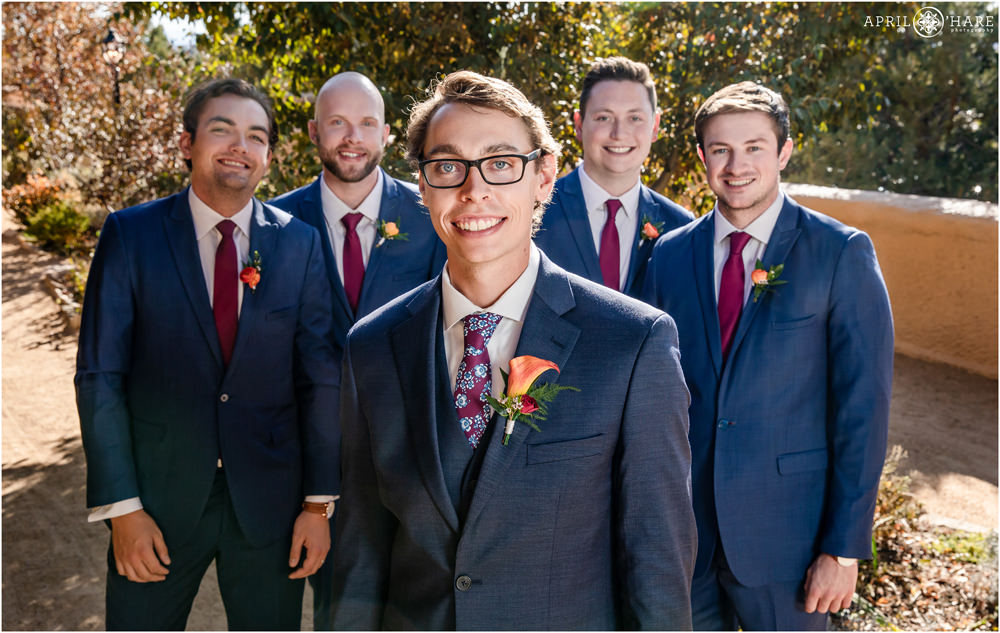 Groom and groomsmen pose for a portrait on a bright sunny wedding day in Colorado