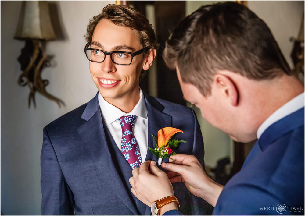 Groom with orange lily boutonniere for fall wedding at Villa Parker in Colorado