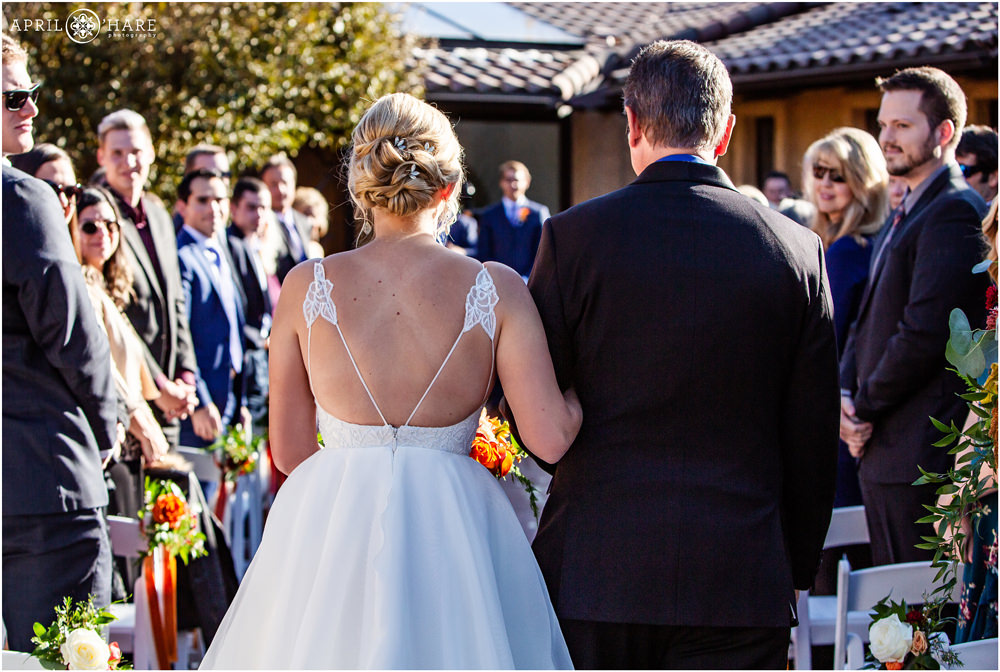 Bride wearing a pretty Hayley Paige gown walks down aisle with her dad at her courtyard wedding ceremony at Villa Parker