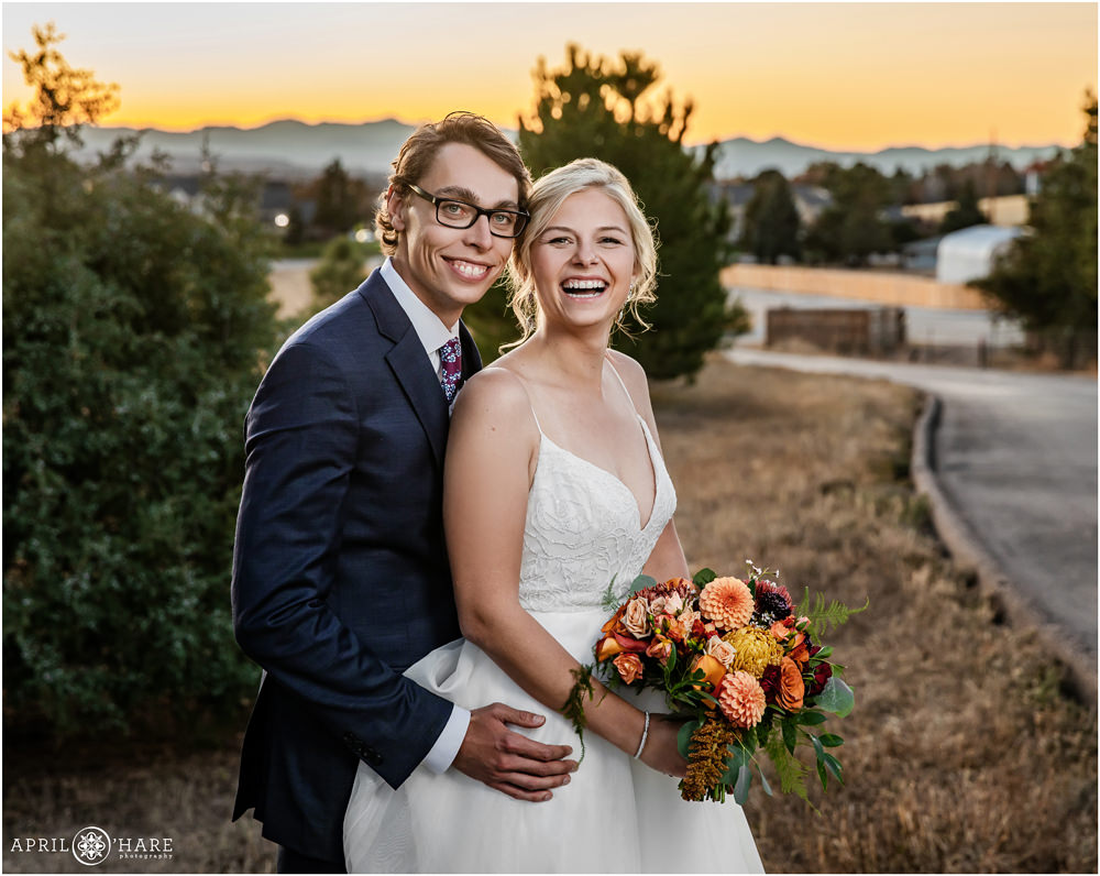 Bride and groom laugh during portraits at sunset at Villa Parker in Colorado