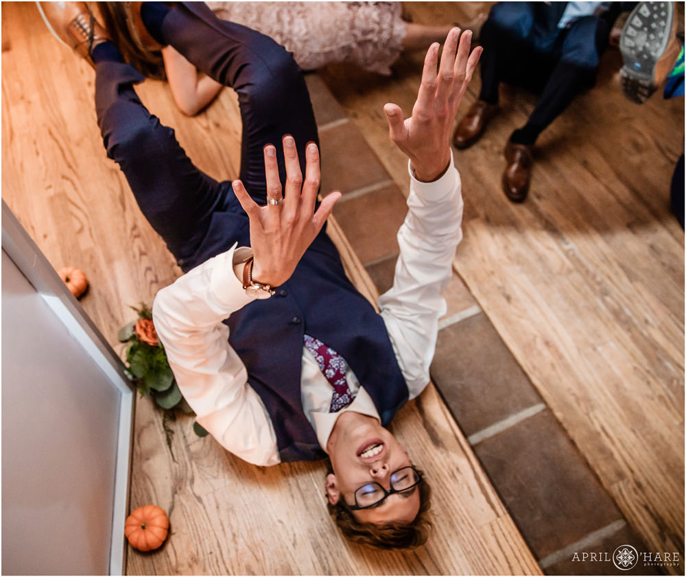 Hilarious photo of groom dancing while on his back at Villa Parker wedding reception in Colorado