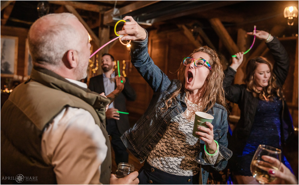 Silly photo of wedding guests dancing and having fun with glow sticks at Piney River Ranch