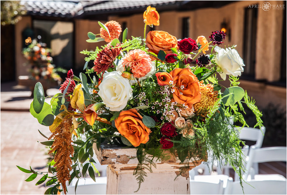Beautiful orange floral decor from an outdoor courtyard ceremony at Villa Parker in Autumn