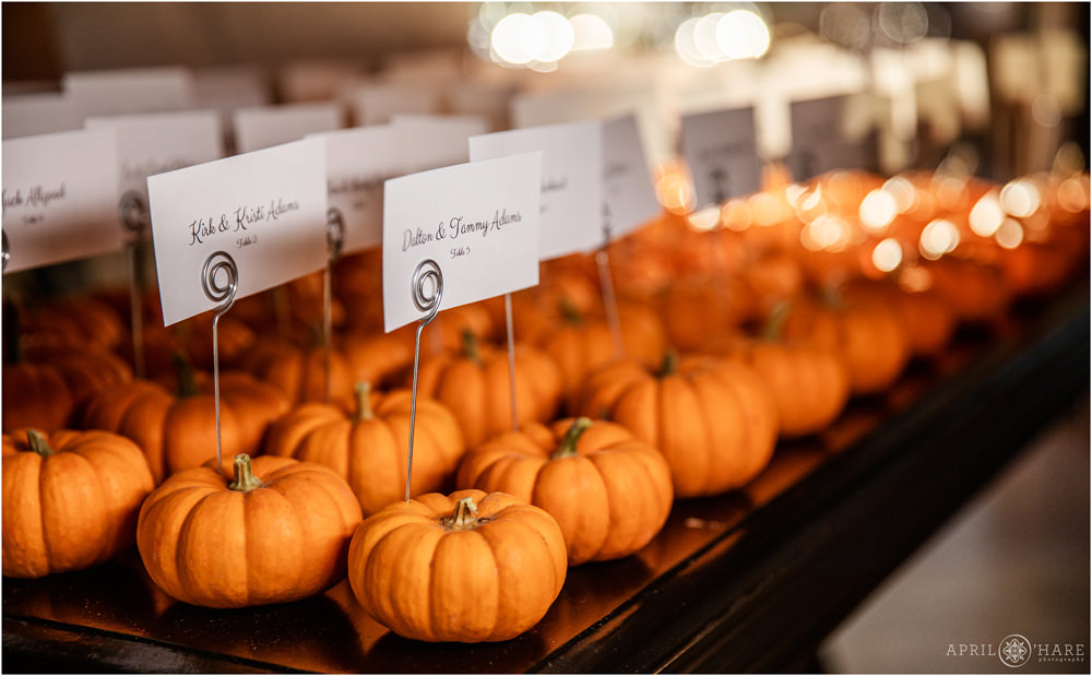 Autumn wedding seating charts using orange mini pumpkins at Villa Parker Colorado