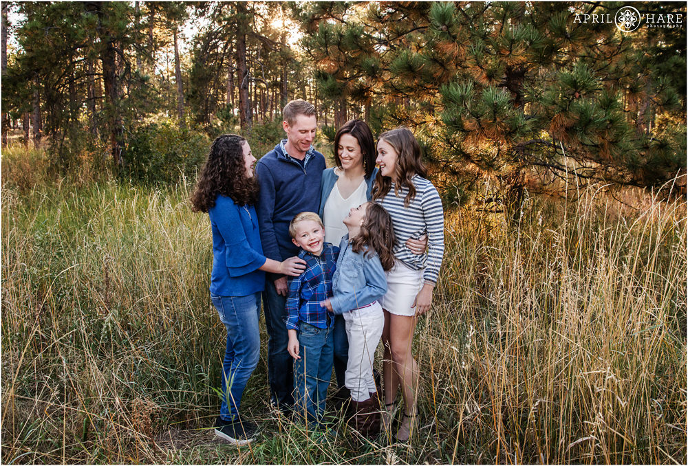 A sweet blended family portrait with laughter in a pine forest setting in Colorado Springs
