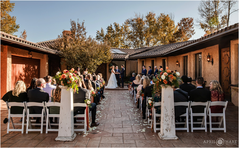 Beautiful outdoor courtyard wedding during fall with orange flowers at Villa Parker in Colorado