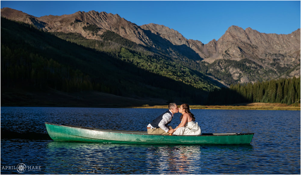 Kissing in a canoe bright sunny wedding day in Vail Colorado
