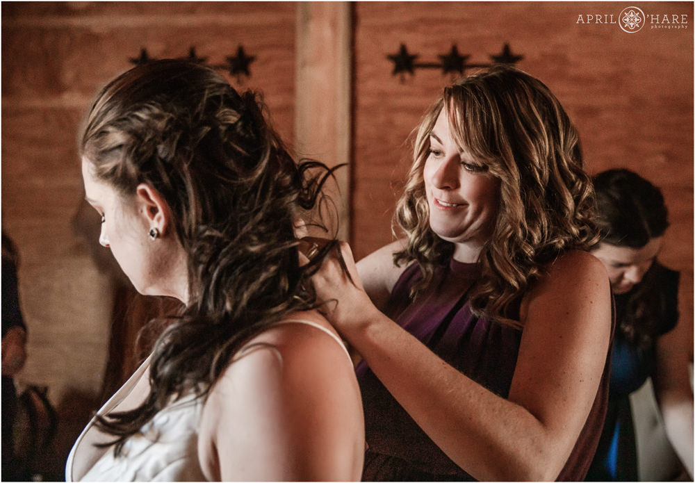 Bridesmaid helps her friend on her wedding day in Vail Colorado